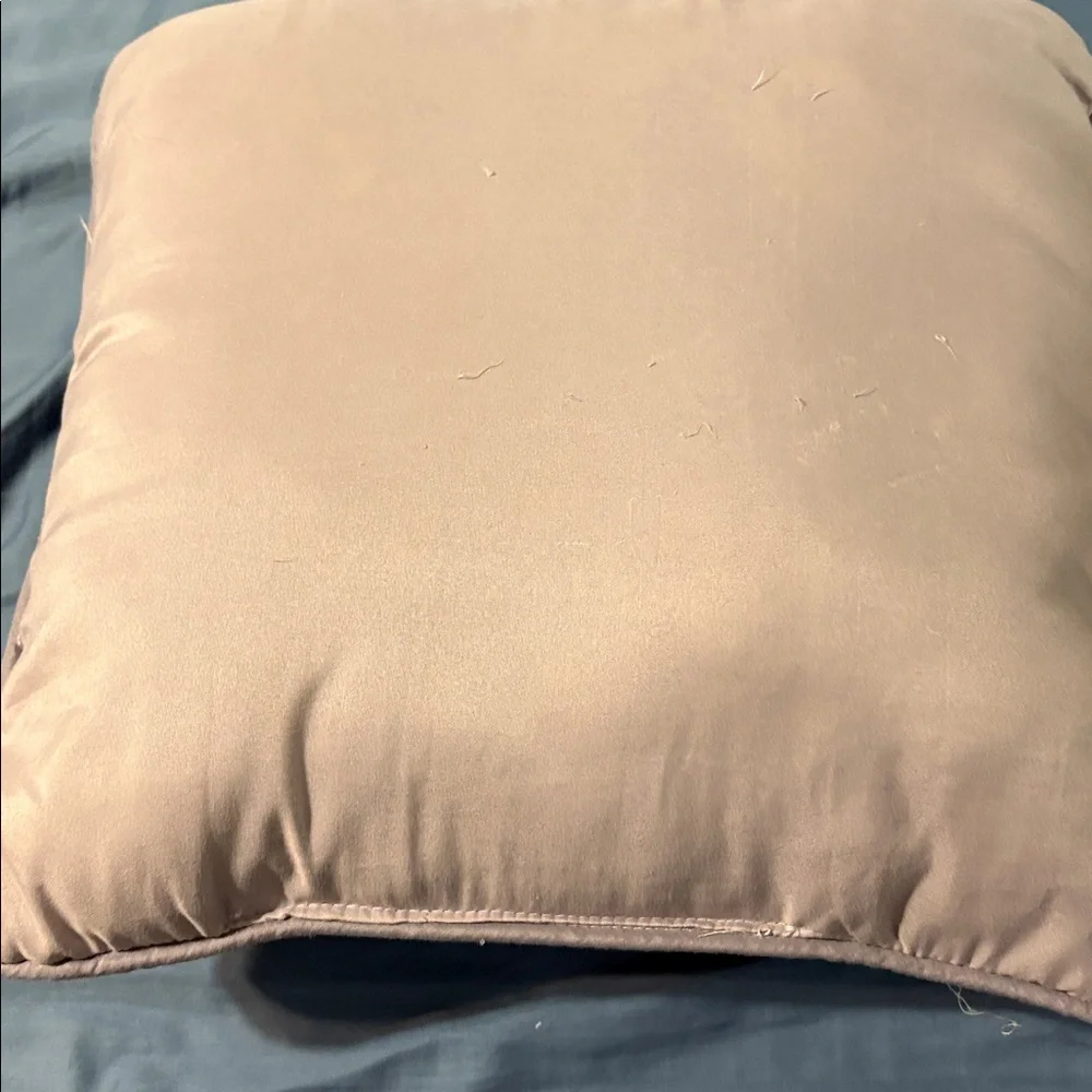 Mauve Quilted Throw Pillow square with some loose strings.